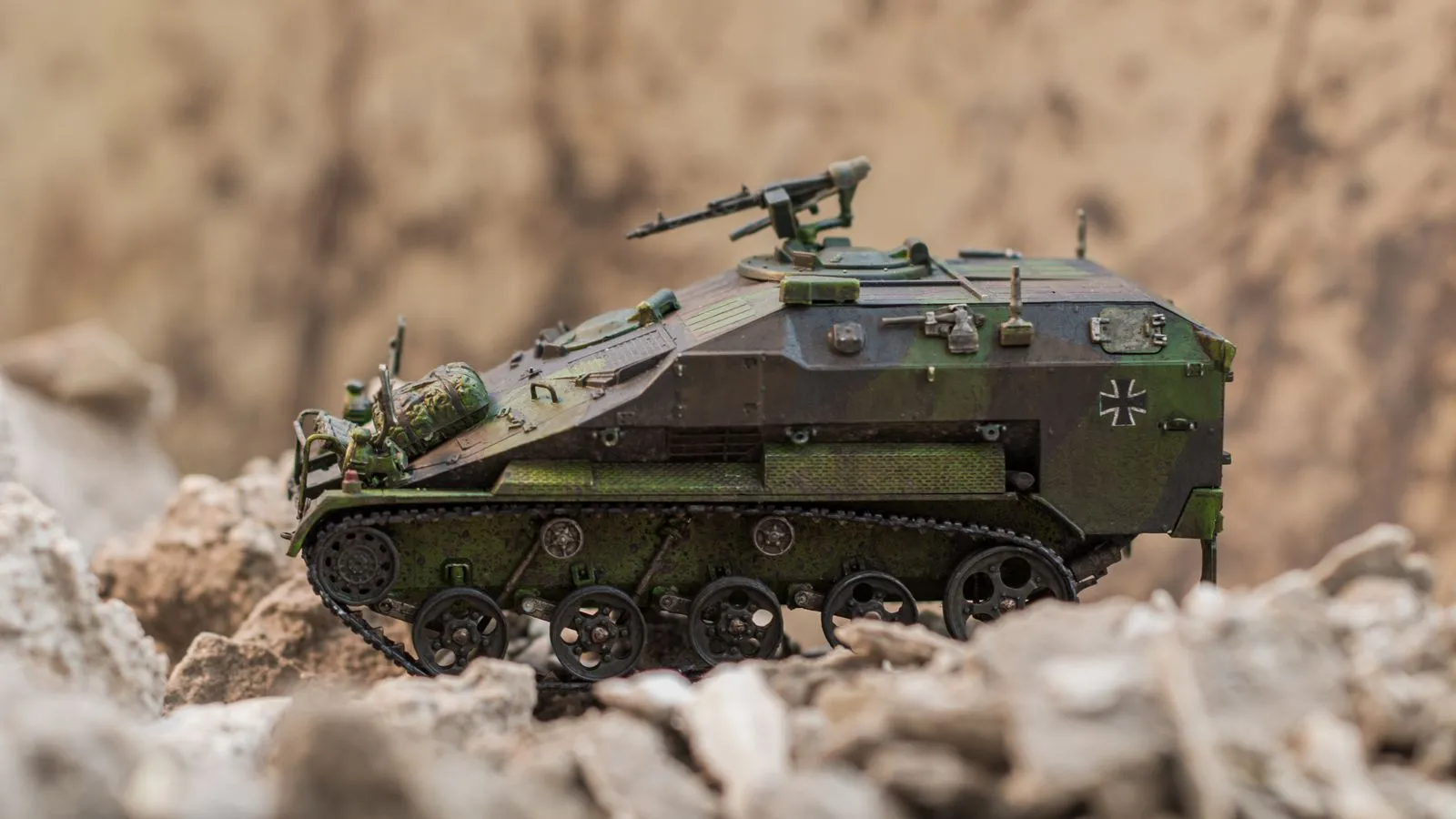 Detailed scale model of a German armored vehicle in a desert-like setting.